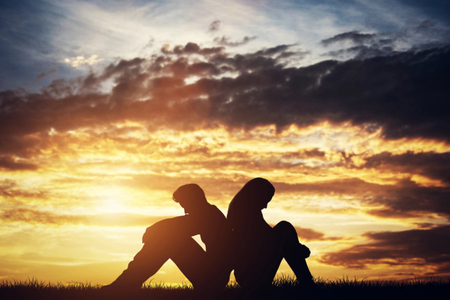 Sad couple sitting back-to-back on a ground. conflict resolution - externally
